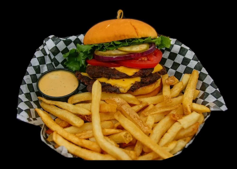 A smashed butter burger with melted American cheese and fries in a checkered basket